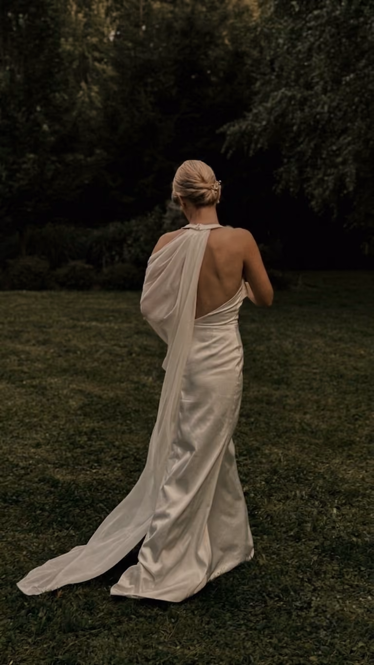 Justyna in her wedding dress on the lawn, seen from behind